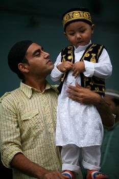 NEPAL, Kathmandu: A Muslim worshipper holds a child while celebrating Eid-al-Adha at a Kasmere Jama mosque in Kathmandu in Nepal on September 25, 2015. The festival marks the end of Hajj, which is a holy pilgrimage that many Muslims make every year. People of Islamic faith have felt more comfortable celebrating Eid ul-Adha in Nepal after the country ushered in a new democratic, secularist constitution