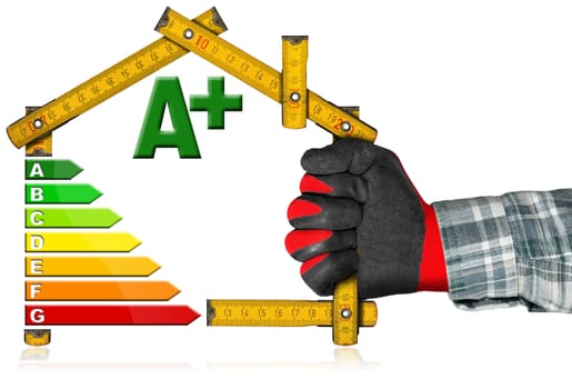 Hand with work glove holding a yellow wooden meter ruler in the shape of house with energy efficiency rating. Isolated on white background.