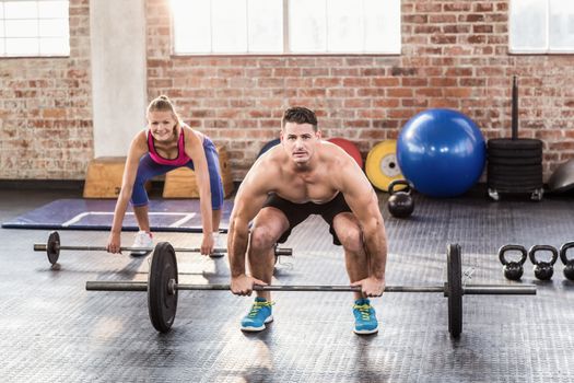 Two fit people working out in crossfit gym