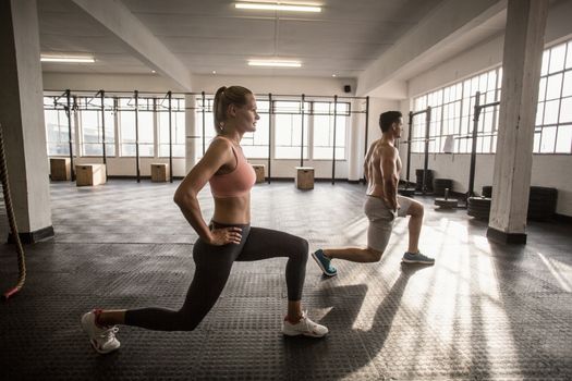 Two fit people doing fitness in crossfit gym