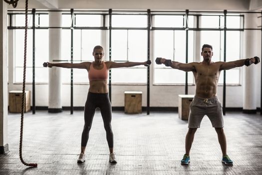 Two fit people doing fitness in crossfit gym