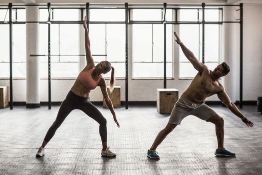 Two fit people doing fitness in crossfit gym