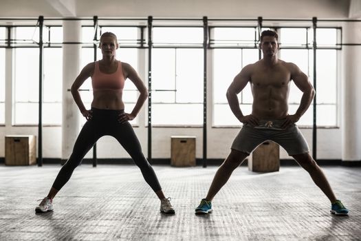 Two fit people doing fitness in crossfit gym