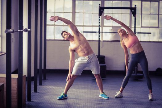 Two fit people doing fitness in crossfit gym