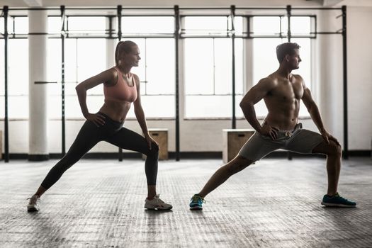 Two fit people doing fitness in crossfit gym