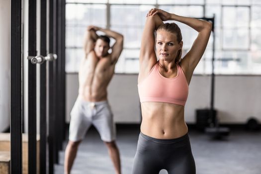 Two fit people doing fitness in crossfit gym