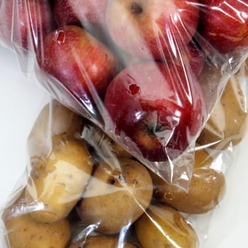 apples and potatoes in preserved inside cellophane bags for food