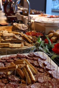 laid table with slices of sausage and bread sticks