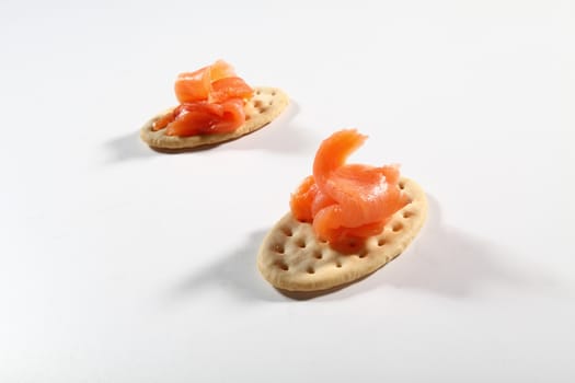 two cracker with salmon on white background