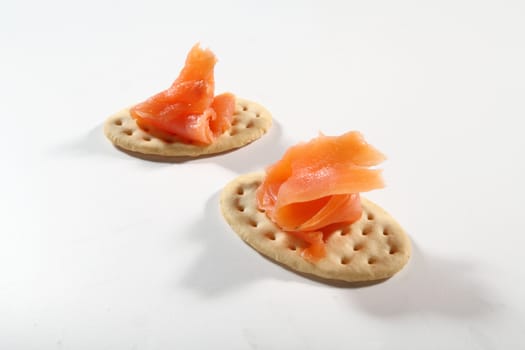 two cracker with salmon on white background