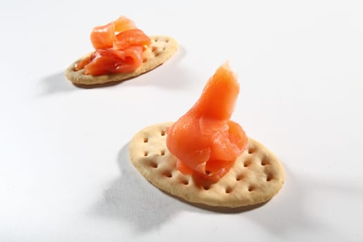 two cracker with salmon on white background