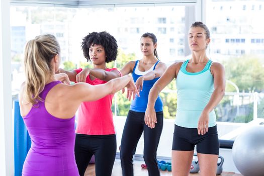 Instructor demonstrating exercise to women in fitness studio