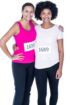 Portrait of happy female athletes standing against white background