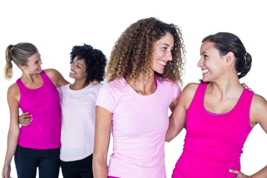 Happy women with arms around while standing against white background