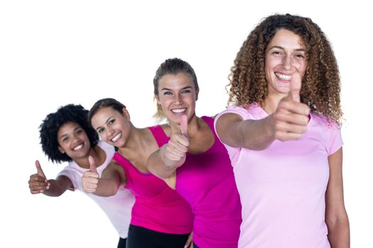 Portrait of smiling women with thumbs up against white background