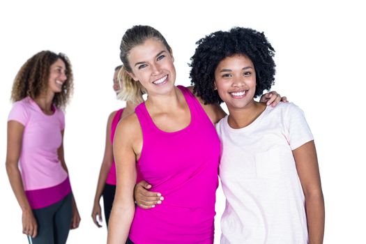 Portrait of cheerful women with arms around while standing against white background