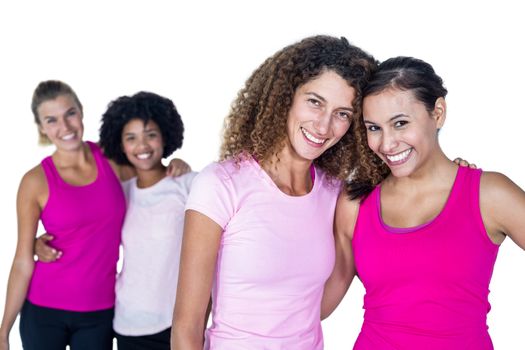 Portrait of happy women with arms around while standing against white background