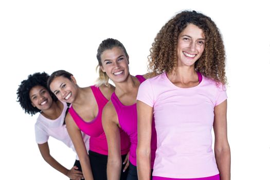 Portrait of smiling women standing in row against white background