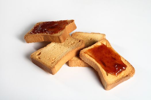 group of four biscuits with jam on a white background