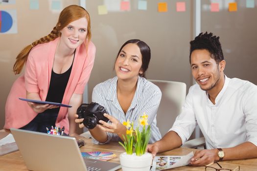 Portrait of smiling business people with camera in office