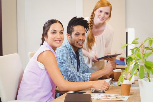 Portrait of smiling business people working together at desk in office