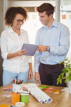 Business people holding document while standing by table in office