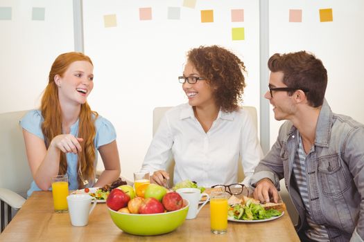 Smiling business people having lunch in creative office