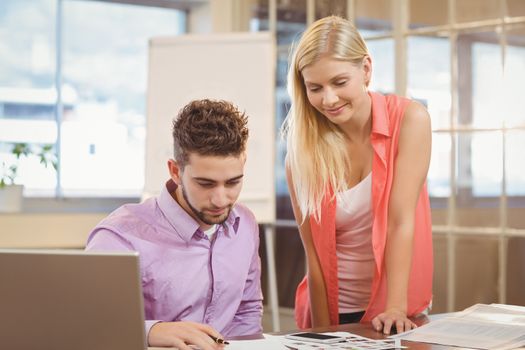 Business people looking at documents on desk in creative office