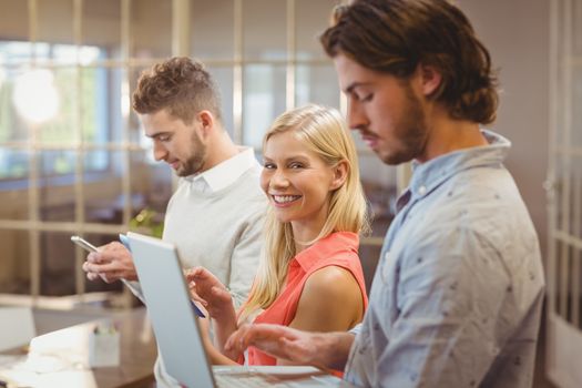 Portrait on smiling businesswoman with male colleagues working in creative office