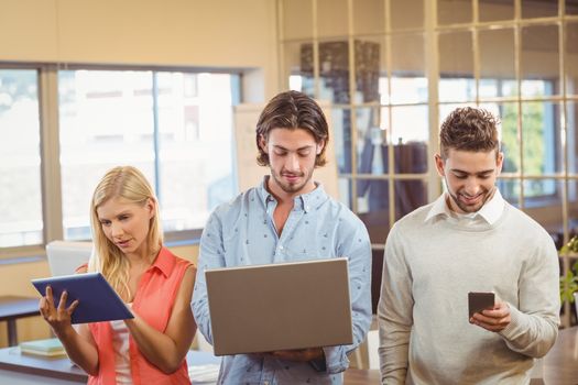 Business people using various technologies in creative office