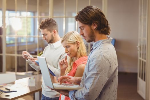 Serious business people working with the help of technologies in creative office