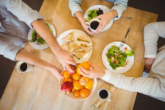 Cropped image of business people having breakfast in canteen at creative office