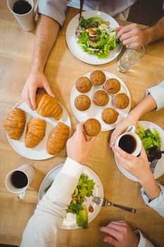 Cropped image of business people having snacks in canteen at creative office