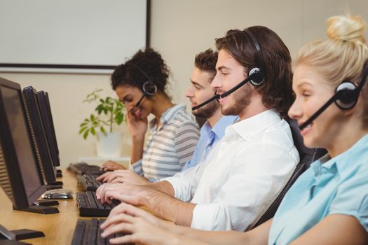 Executives working in call center wearing headsets
