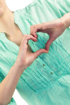 Mid section of woman with heart shape of fingers against white background