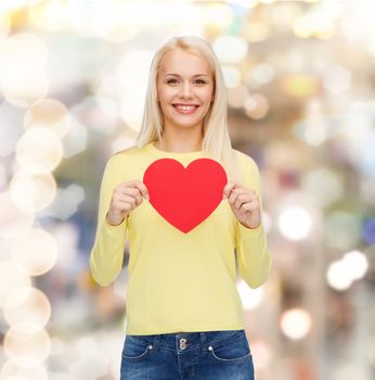 happiness, health and love concept - smiling woman with red heart