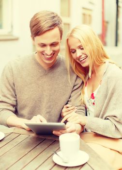 summer holidays, dating and technology concept - couple looking at tablet pc in cafe in the city