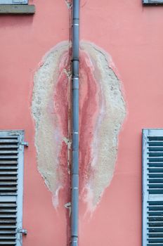 Photo of an old dirty wall with a damaged drain pipe for rain water.