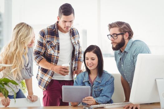 Business professionals using tablet while sitting at desk in office