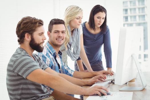 Creative business team working on computer at desk in office