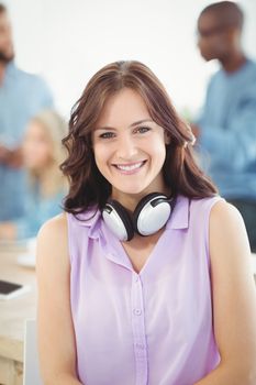 Portrait of smiling woman with headphones in office