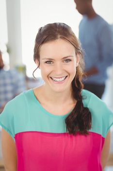 Portrait of happy woman while standing at office