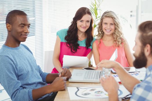 Portrait of smiling women sitting at desk in office