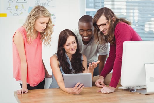 Business team using digital tablet at desk in office