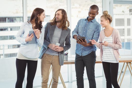 Business team using technology while standing at creative office