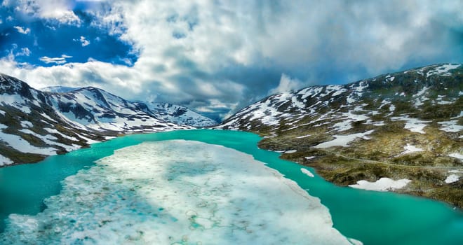 Frozen lake in norwegian mountains on Gamle Strynefjellsvegen mountain pass, aerial panorama