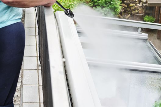 Exterior cleaning and building cleaning a glass roof with high pressure water jet.