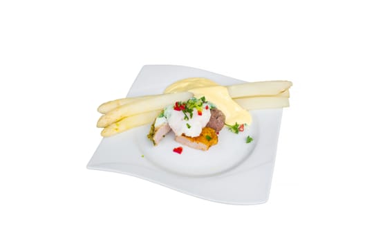 White asparagus with salad on pork and beef fillet. Isolated. Tradition German food. View from above.