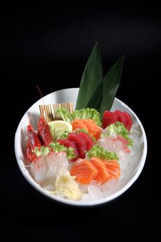 round plate of sashimi and sushi with mixed vegetables and ice