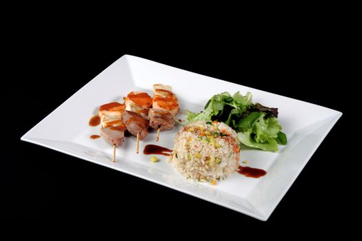 menu of kebabs with rice and vegetables in white dish, on black background